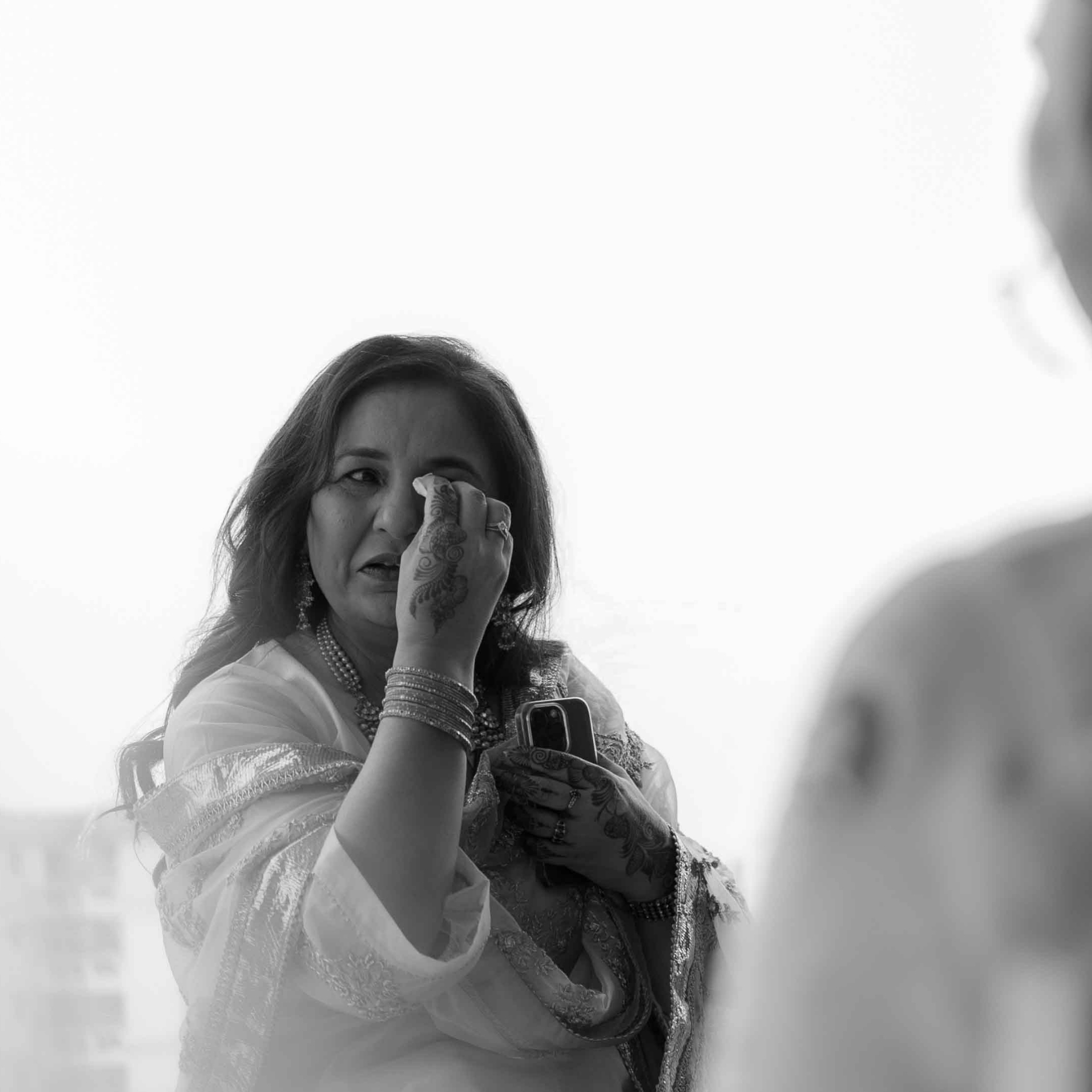 A mother wiping her eye in black-and-white