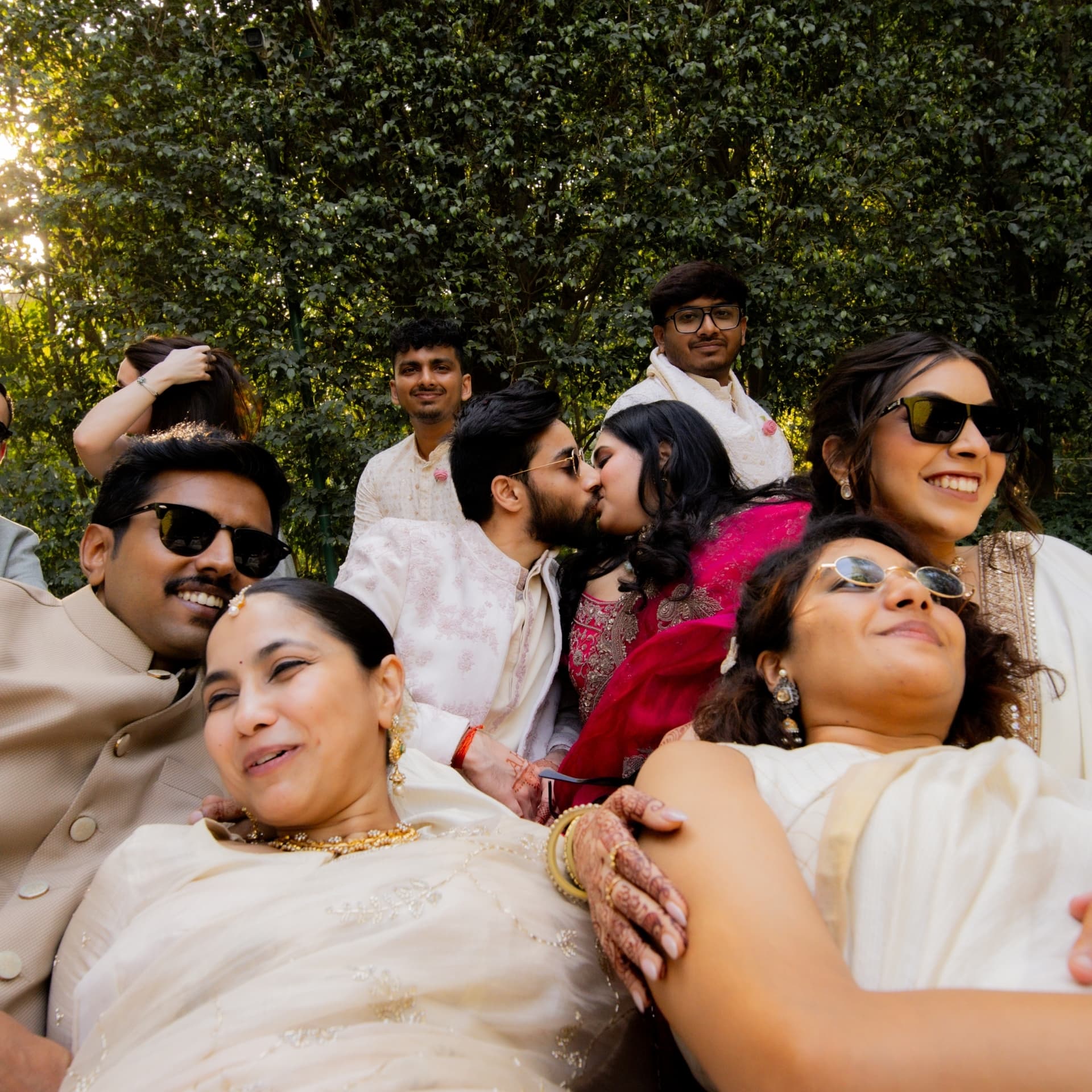 A couple kissing amid their gathered friends