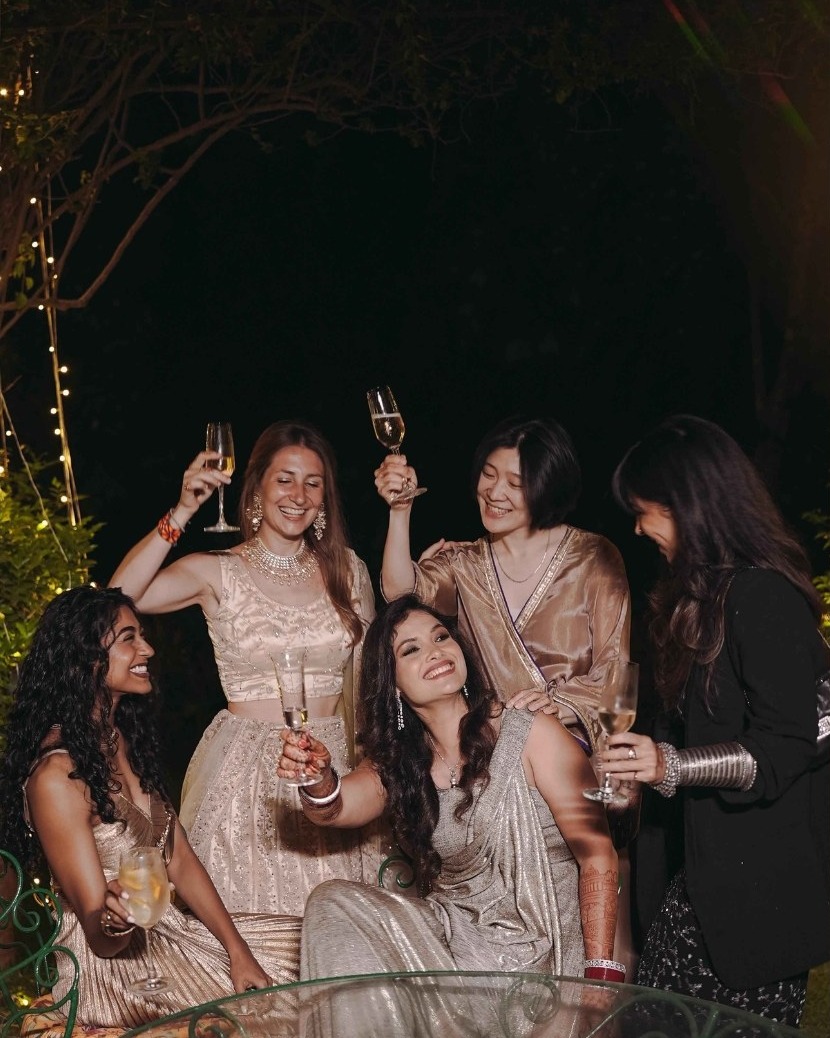 Friends raising glasses around the bride at an evening celebration